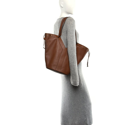 Calfskin Y drawstring tote bag on a model, tan-brown color, side tie details