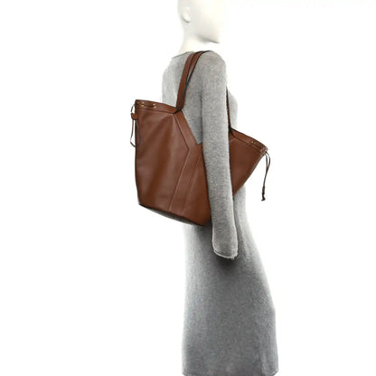 Calfskin Y drawstring tote bag on a model, tan-brown color, side tie details