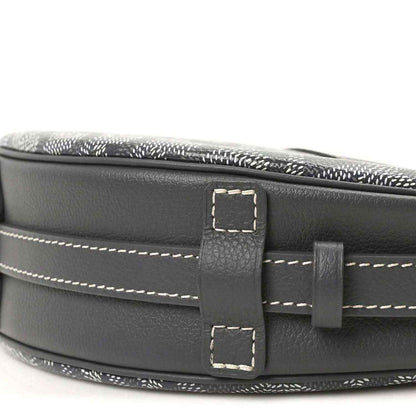 Dark leather strap attachment with rectangular buckle on canvas bag