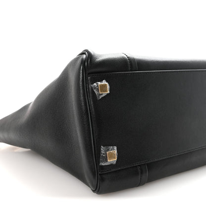 Black leather bag corner with gold-tone snap hardware.