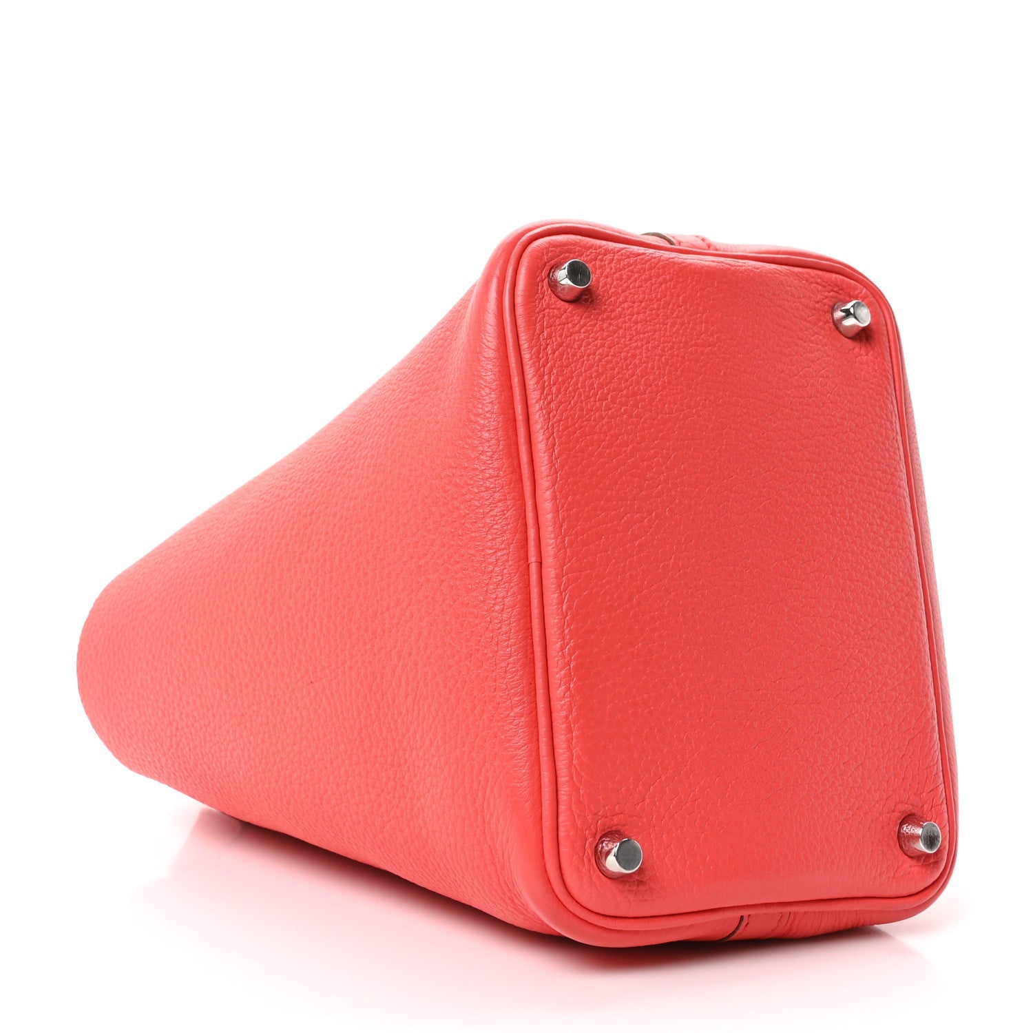 Red leather tote bag corner with metal feet and rounded base