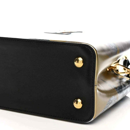 Bottom corner close-up of handbag with gold studs and black leather edge trim