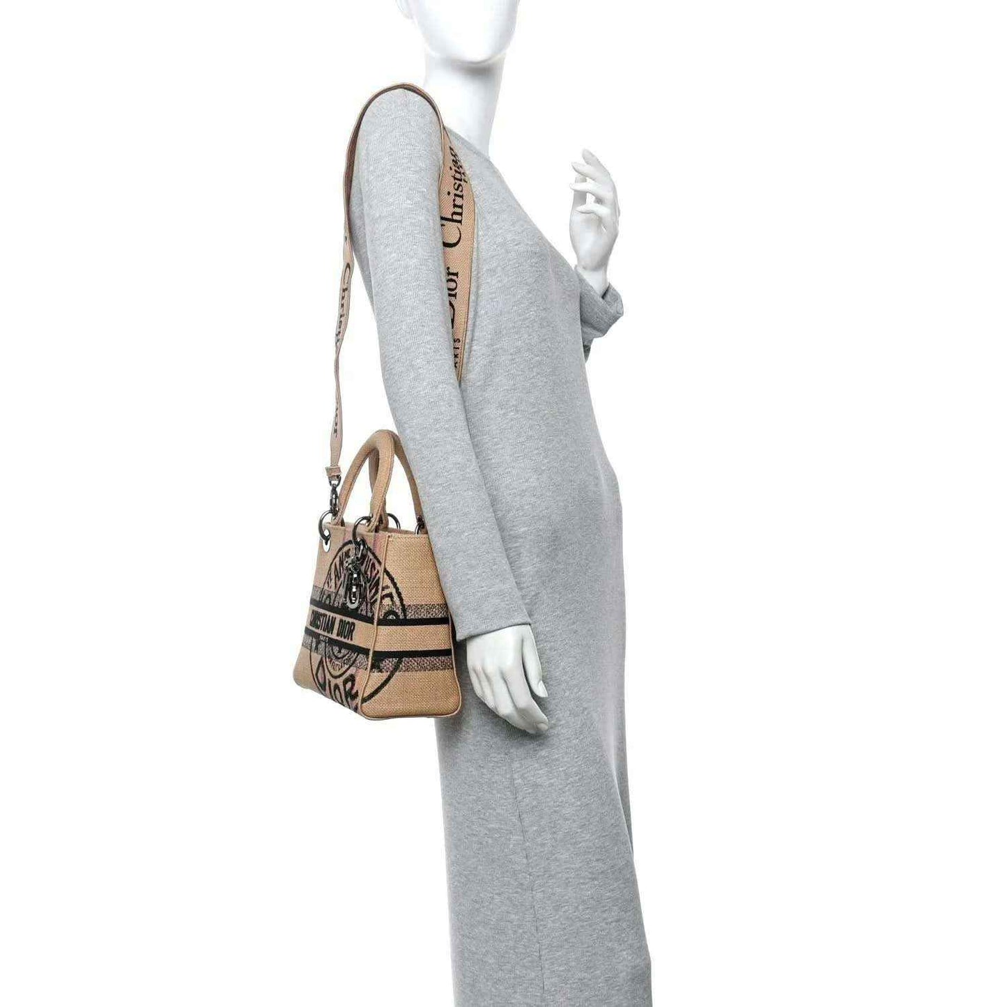 Jute canvas bag worn crossbody by model, tan strap, embroidered logo front.