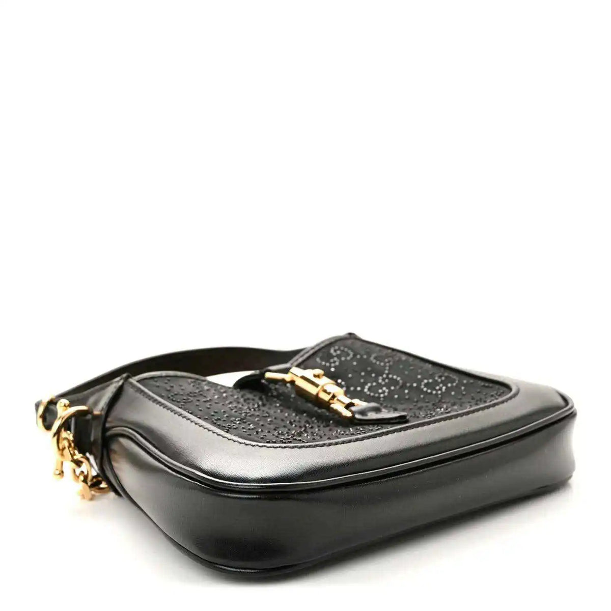 Black hobo bag with gold hardware and a top flap clasp, side view.