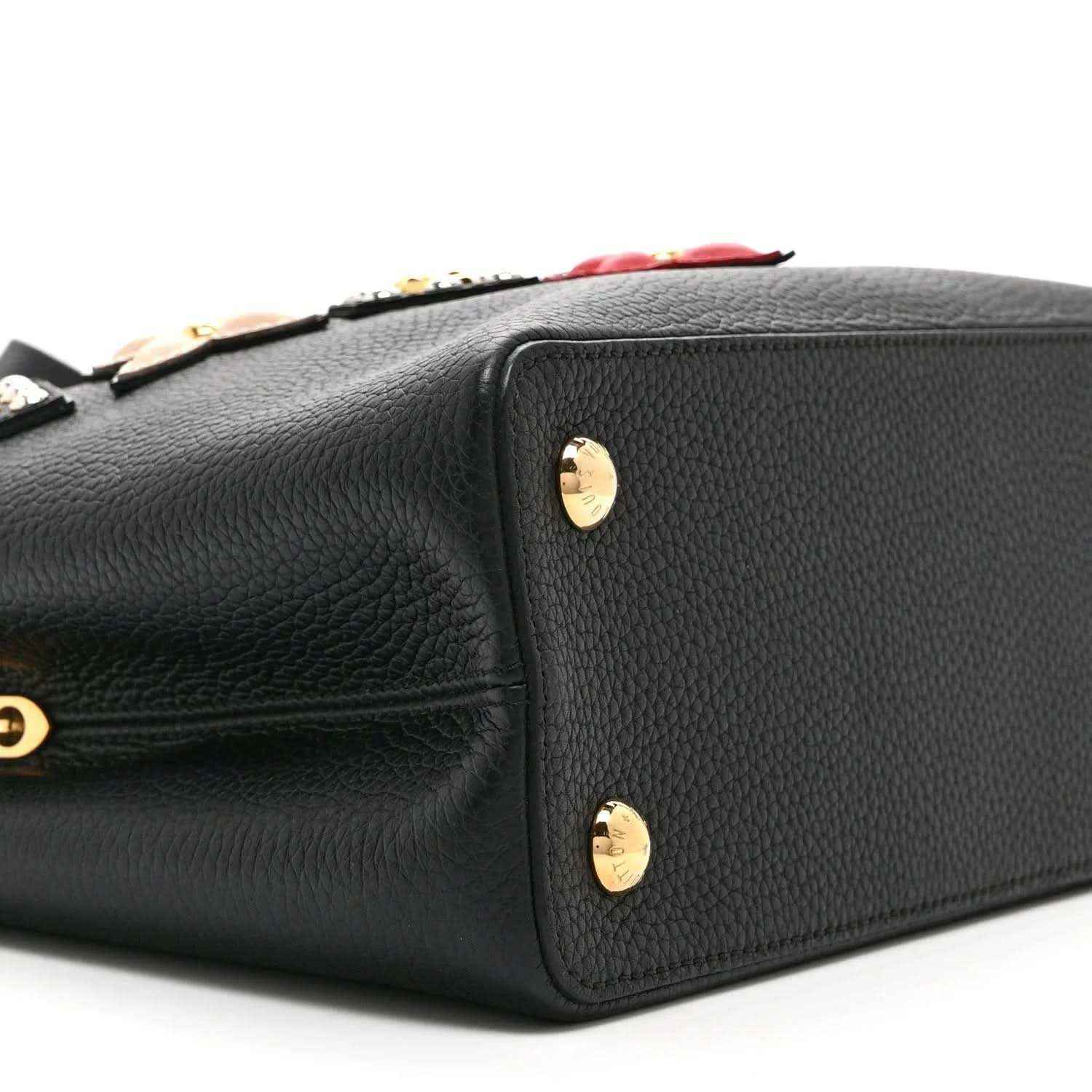 Black Louis Vuitton handbag back panel with gold stud feet and embossed leather texture