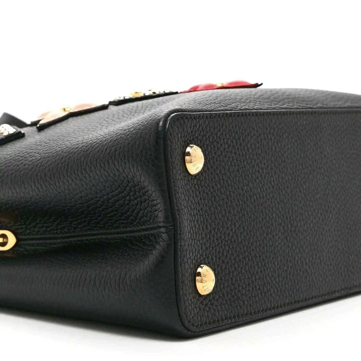 Black Louis Vuitton handbag back panel with gold stud feet and embossed leather texture
