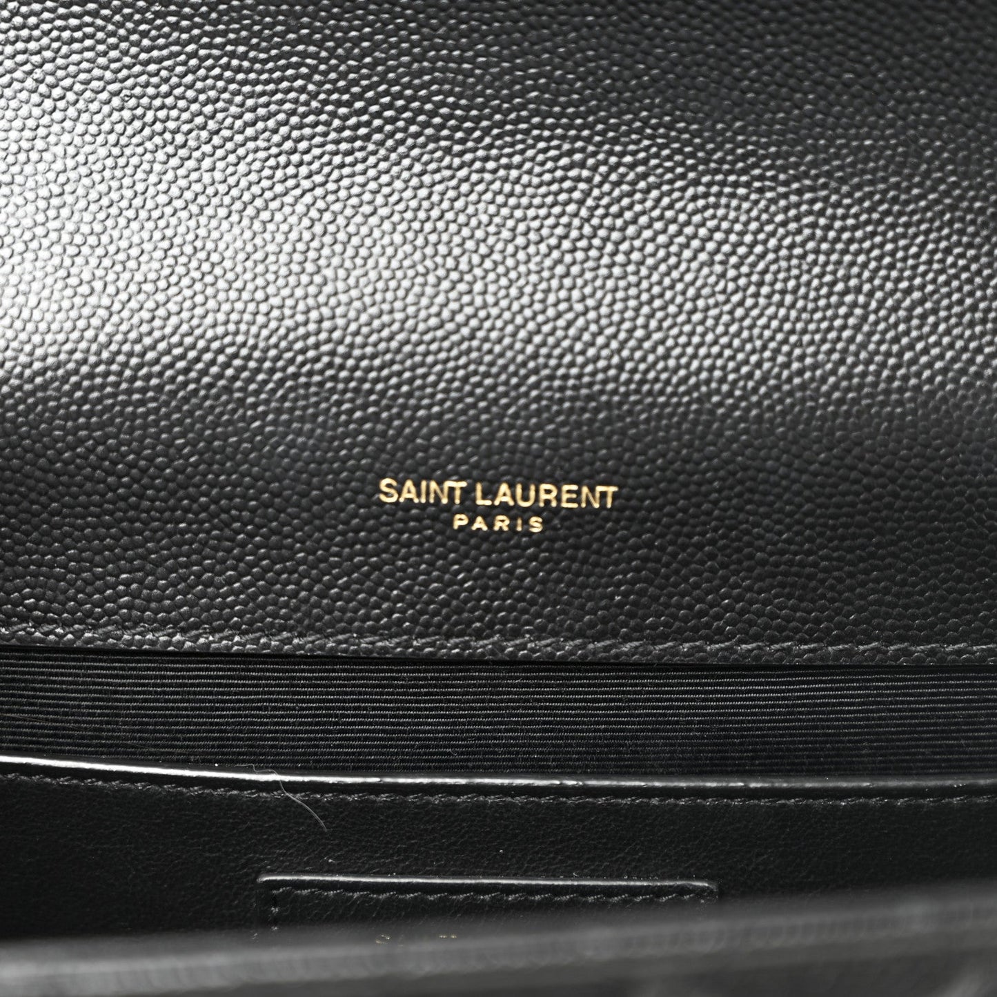 Black pebbled leather with embossed “SAINT LAURENT PARIS” branding