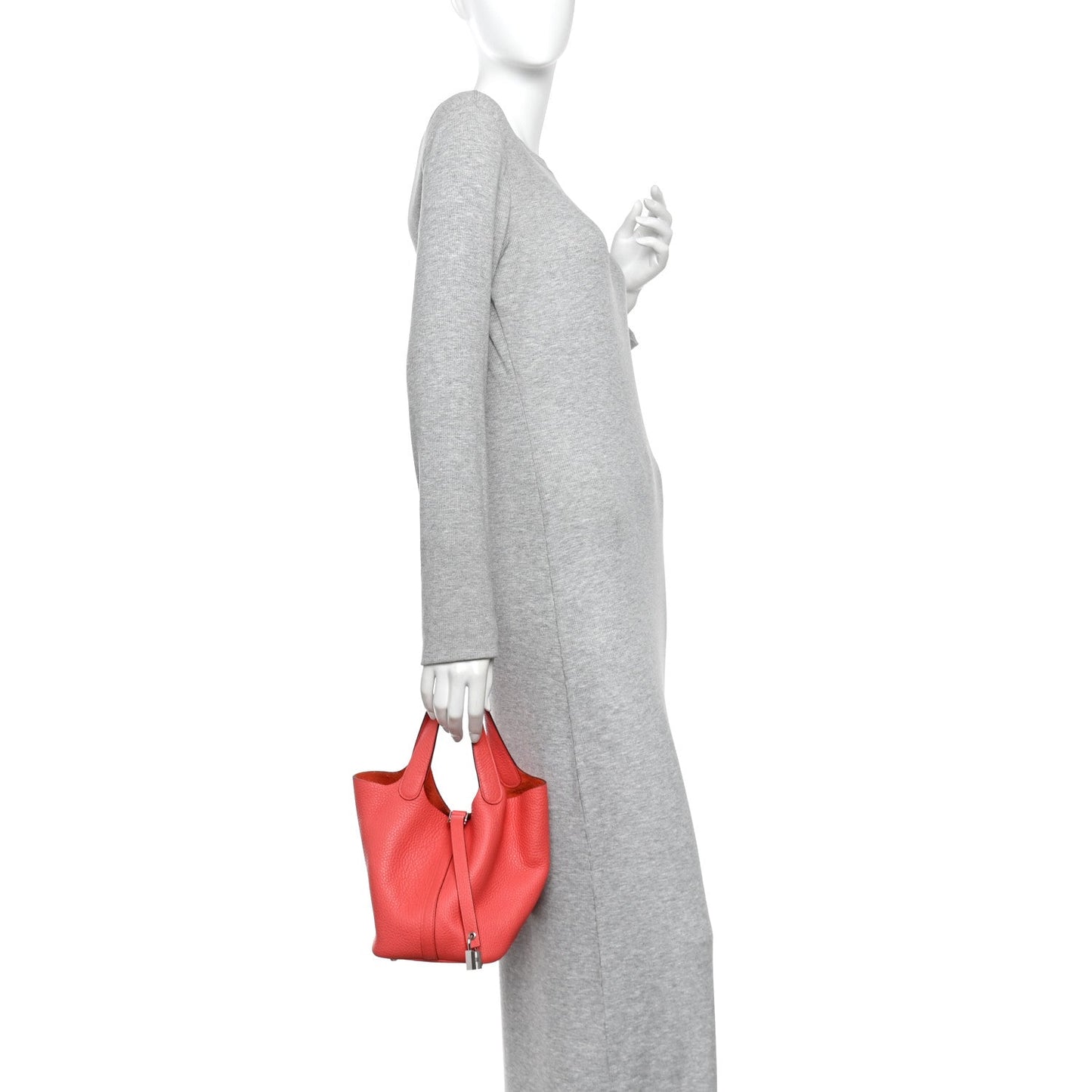 Rose pink leather tote bag worn by person, with top handles and lock clasp