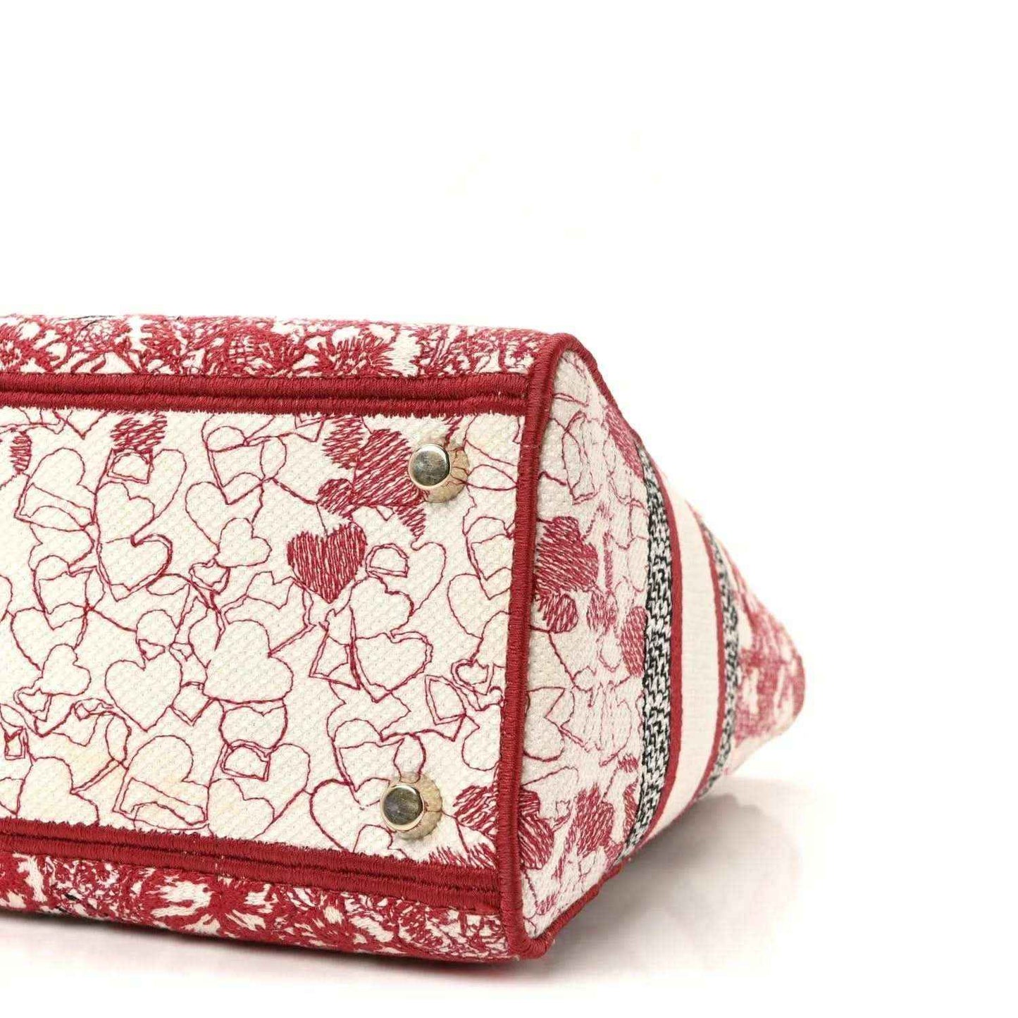 Handbag side panel with floral embroidery, red trim, and two silver rivet snaps