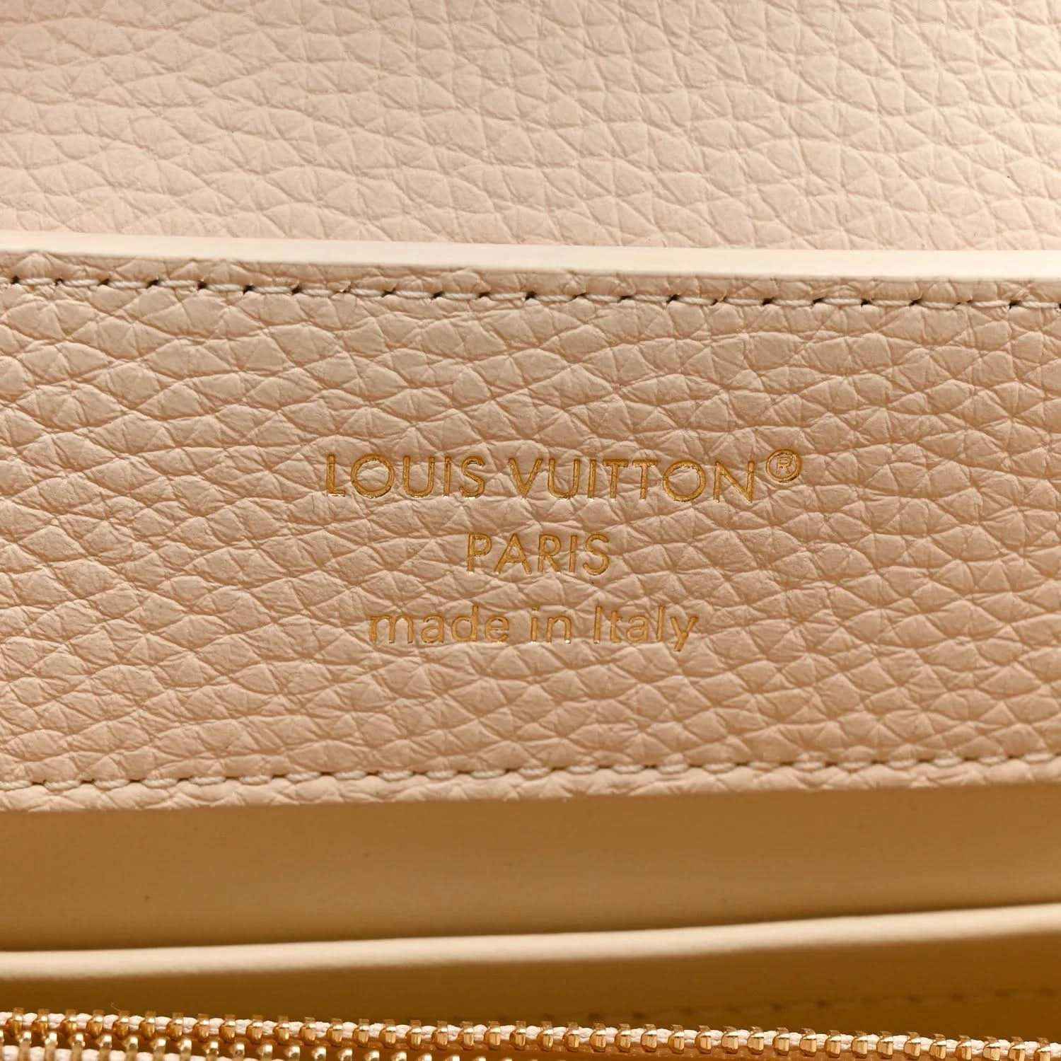 Louis Vuitton leather panel with engraved brand text and zipper edge