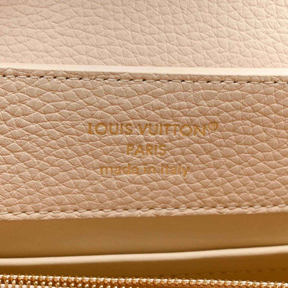 Louis Vuitton leather panel with engraved brand text and zipper edge