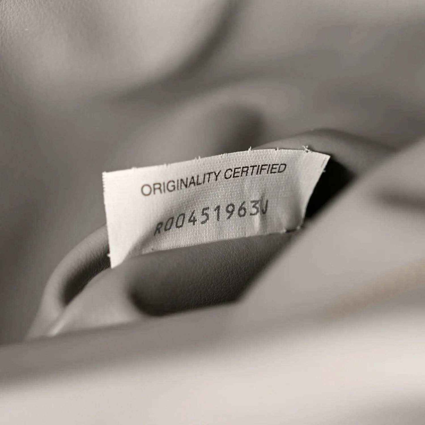 Suede authenticity tag reading Originality Certified with code