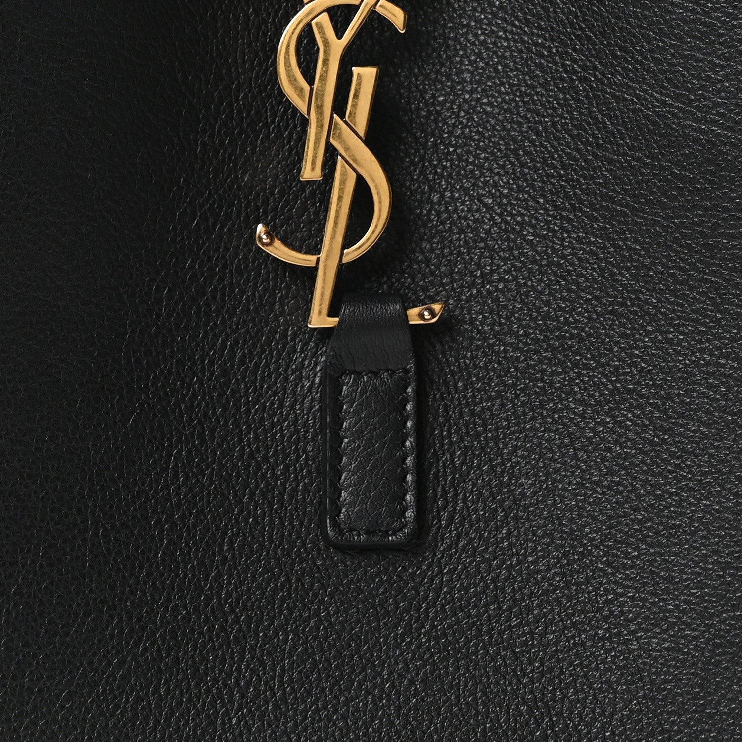 Black leather hobo bag with gold YSL monogram on a hanging leather tab