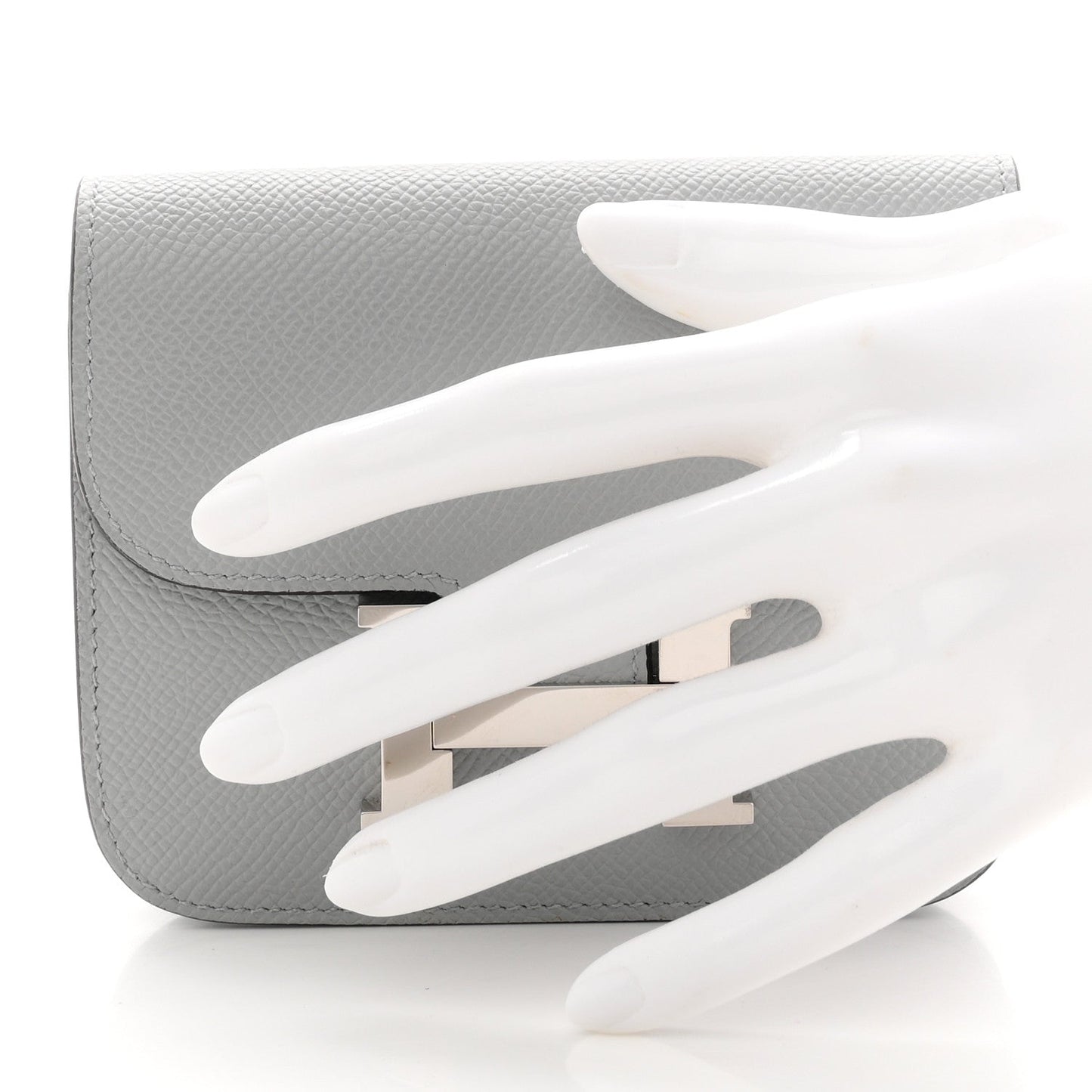Hermes Constance slim wallet, light blue textured leather, open flap with H clasp.