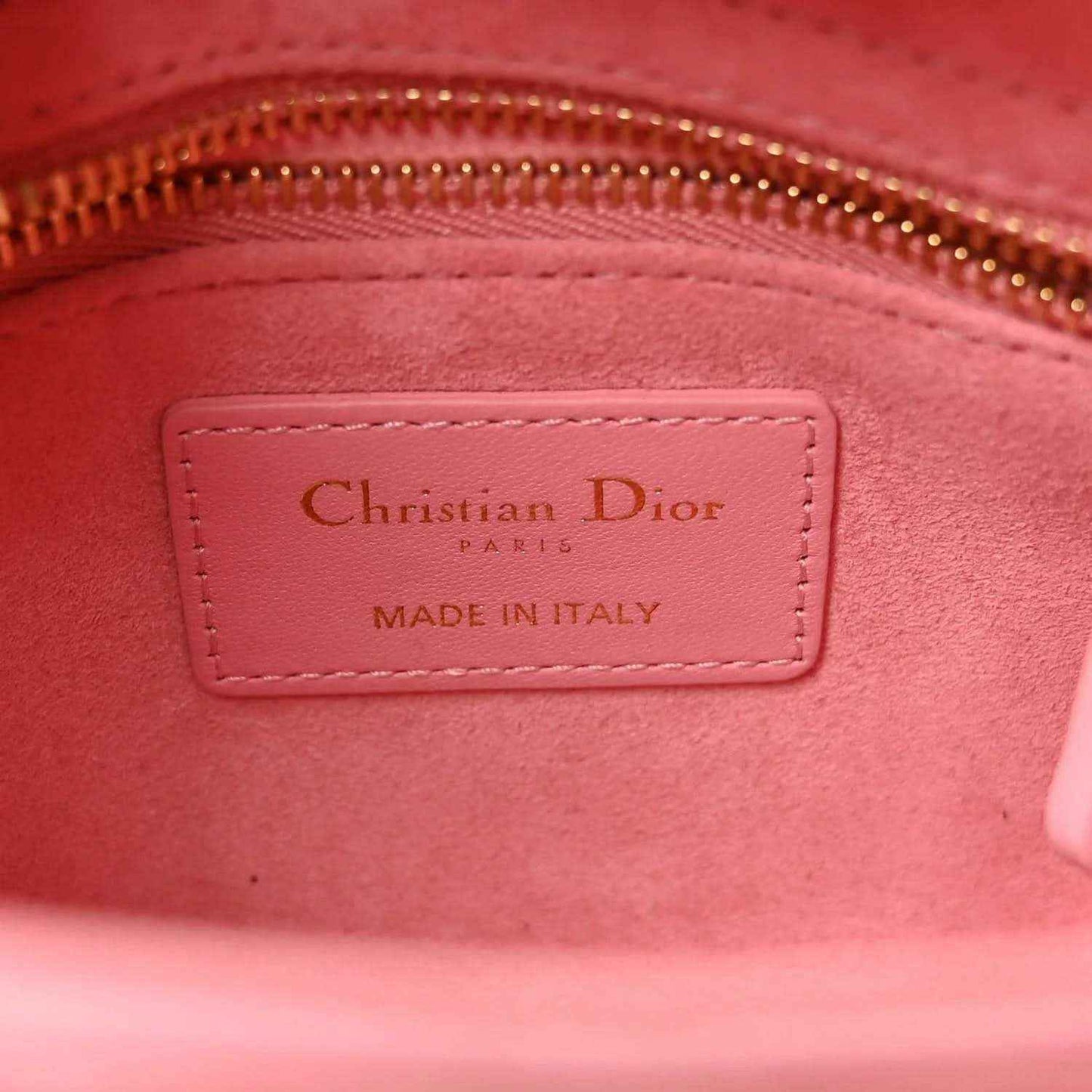 Light pink handbag interior label reading Christian Dior and Made in Italy
