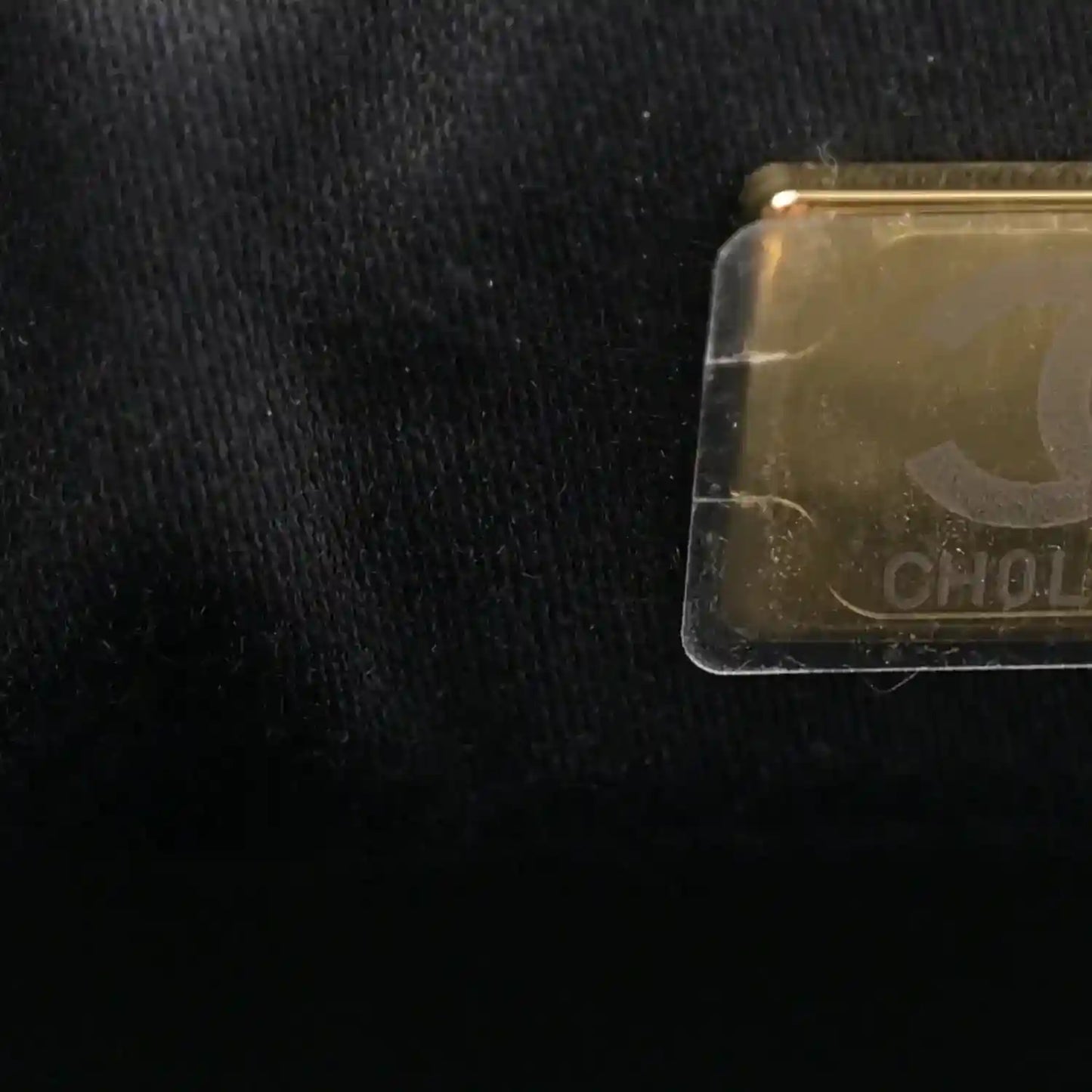 Transparent tag on black leather handbag fabric
