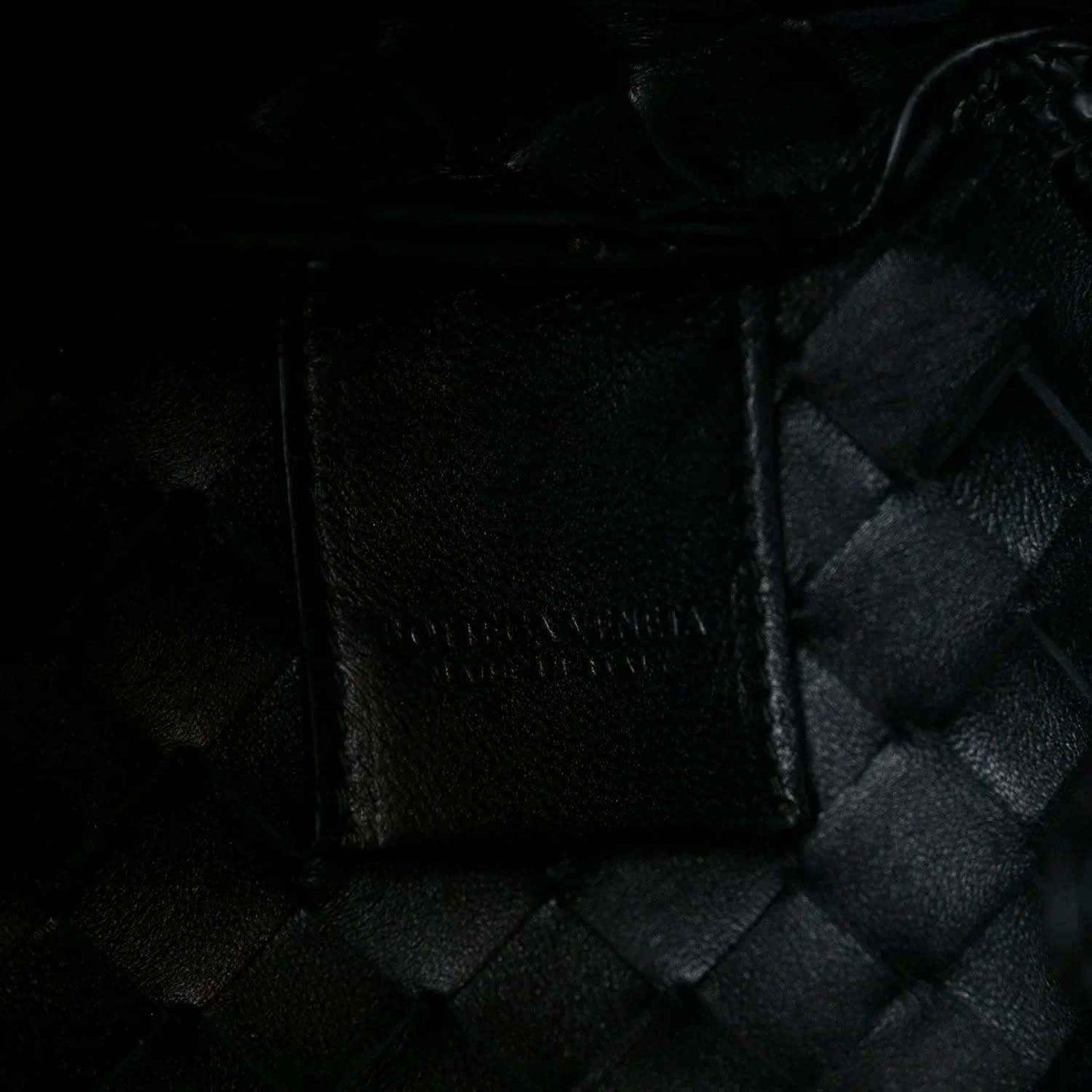 Black leather intrecciato panel with textured stitch detail and seam edges