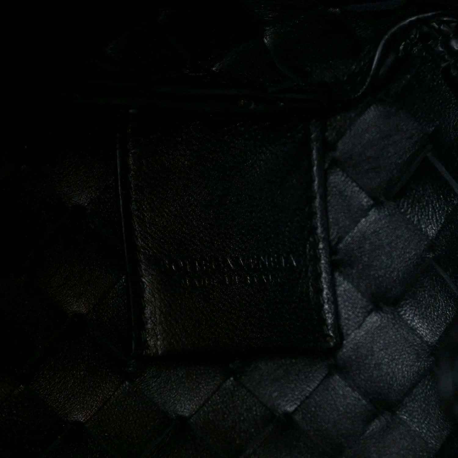 Black leather intrecciato panel with textured stitch detail and seam edges