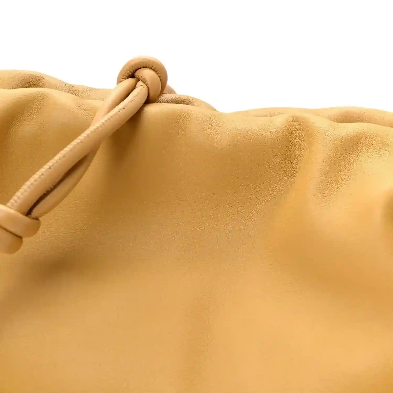 Tan leather clutch top with knotted drawstring cord and braided pull tab