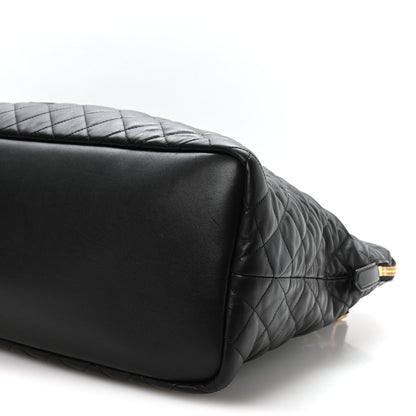 Black quilted leather travel bag corner with smooth base panel and gold hardware