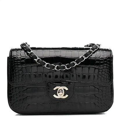 Black shiny alligator mini rectangular flap bag with chain strap and Chanel logo.