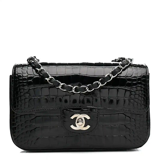 Black shiny alligator mini rectangular flap bag with chain strap and Chanel logo.