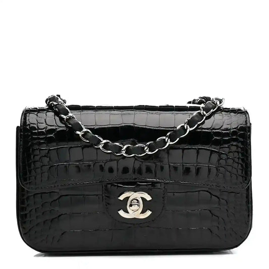 Black shiny alligator mini rectangular flap bag with chain strap and Chanel logo.