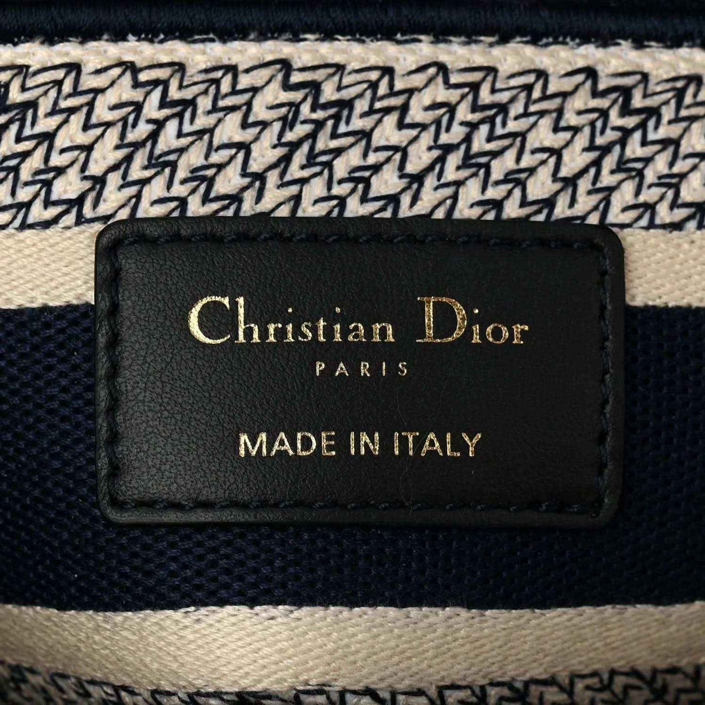 Blue toile de Jouy handbag interior brand label reading “Christian Dior” and “Made in Italy”.
