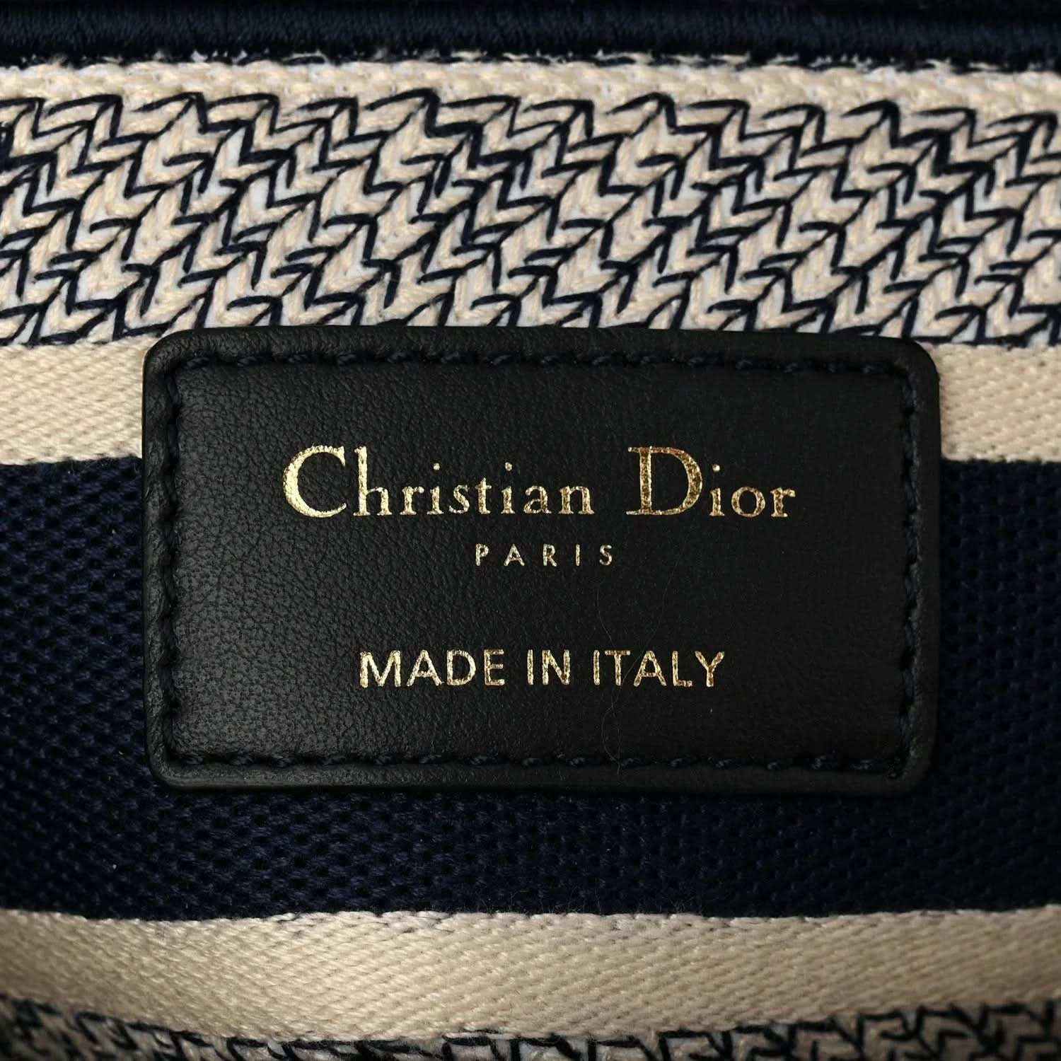 Blue toile de Jouy handbag interior brand label reading “Christian Dior” and “Made in Italy”.