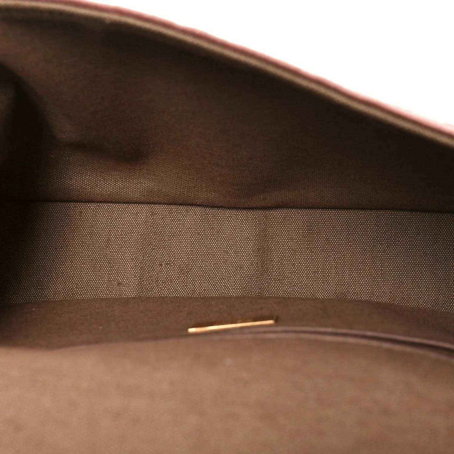 Dark interior lining of a baguette bag with zipper track at the top opening