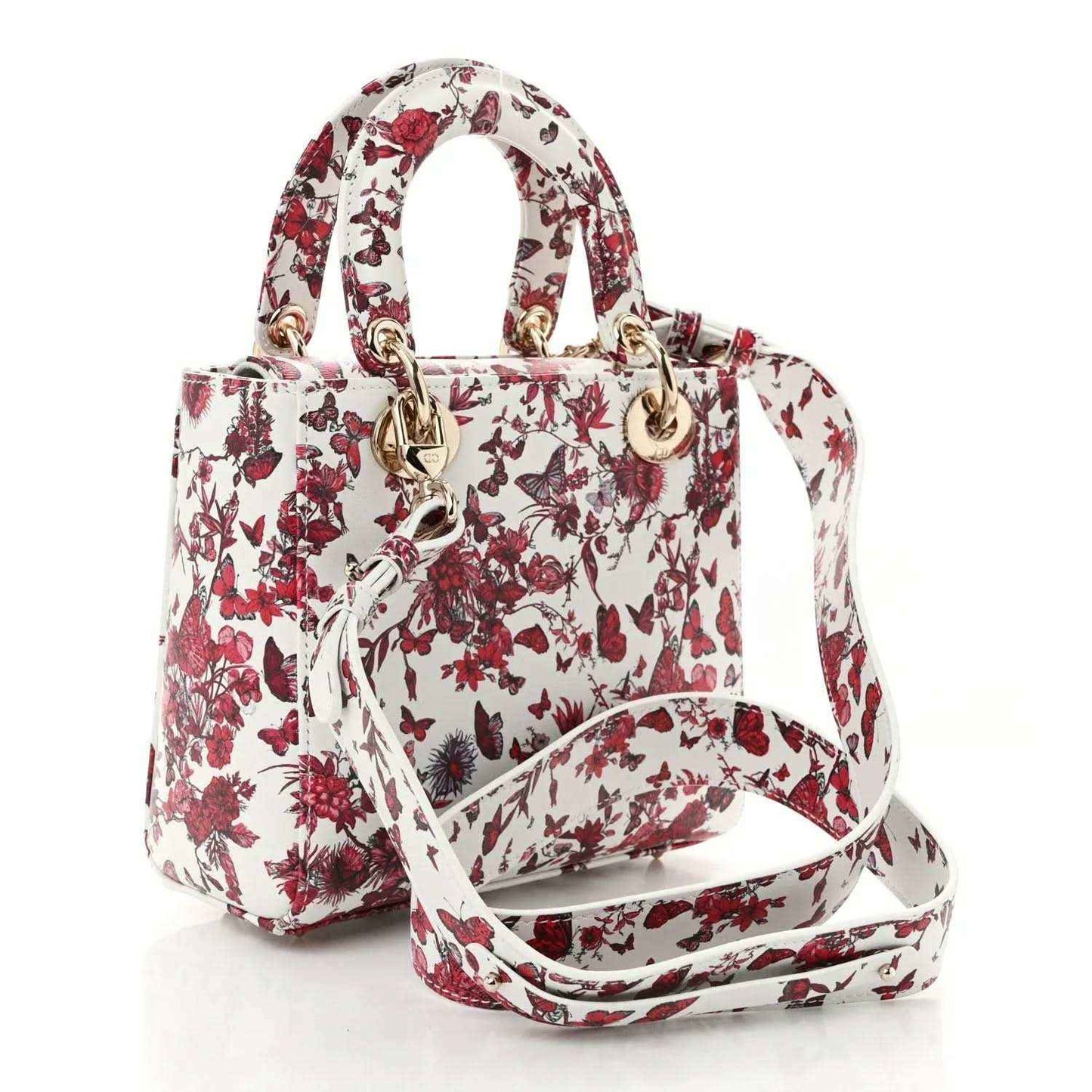 Small floral handbag with white-and-red pattern, top handles, and crossbody strap