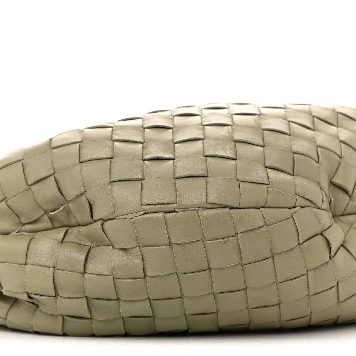 Close-up of woven leather bag exterior with curved seam, travertine light taupe
