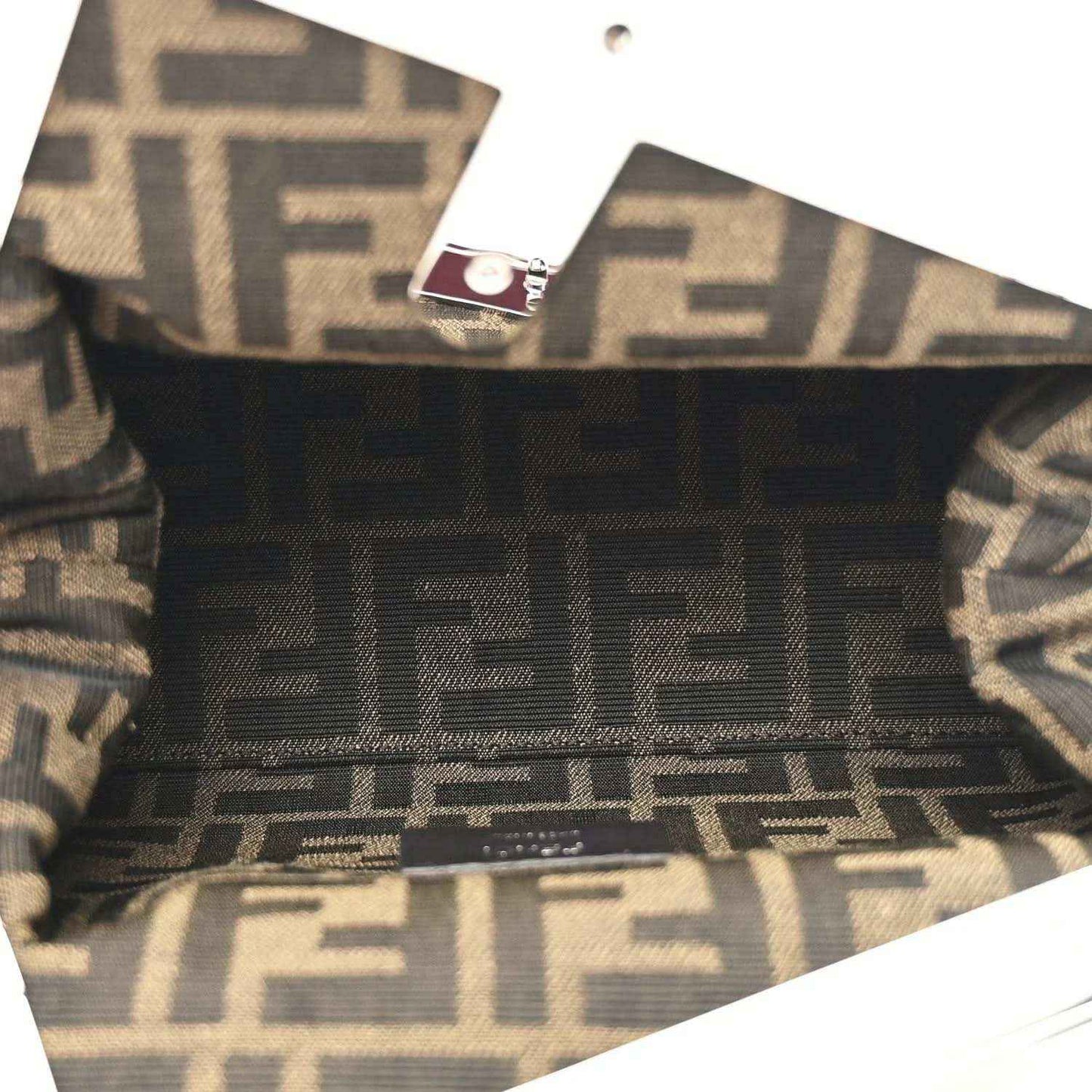Fendi-lined clutch interior with monogram pattern and fabric trim visible