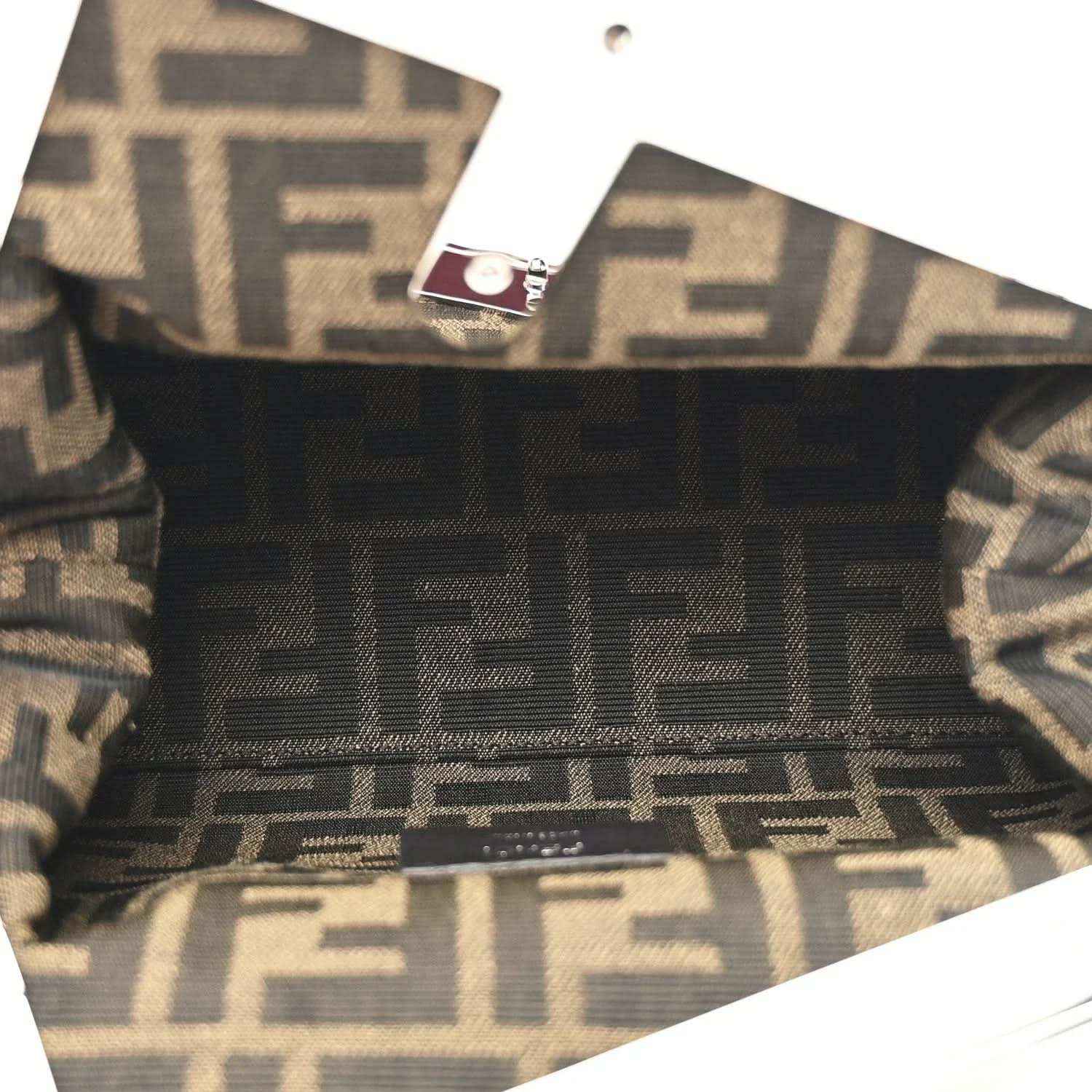 Fendi-lined clutch interior with monogram pattern and fabric trim visible