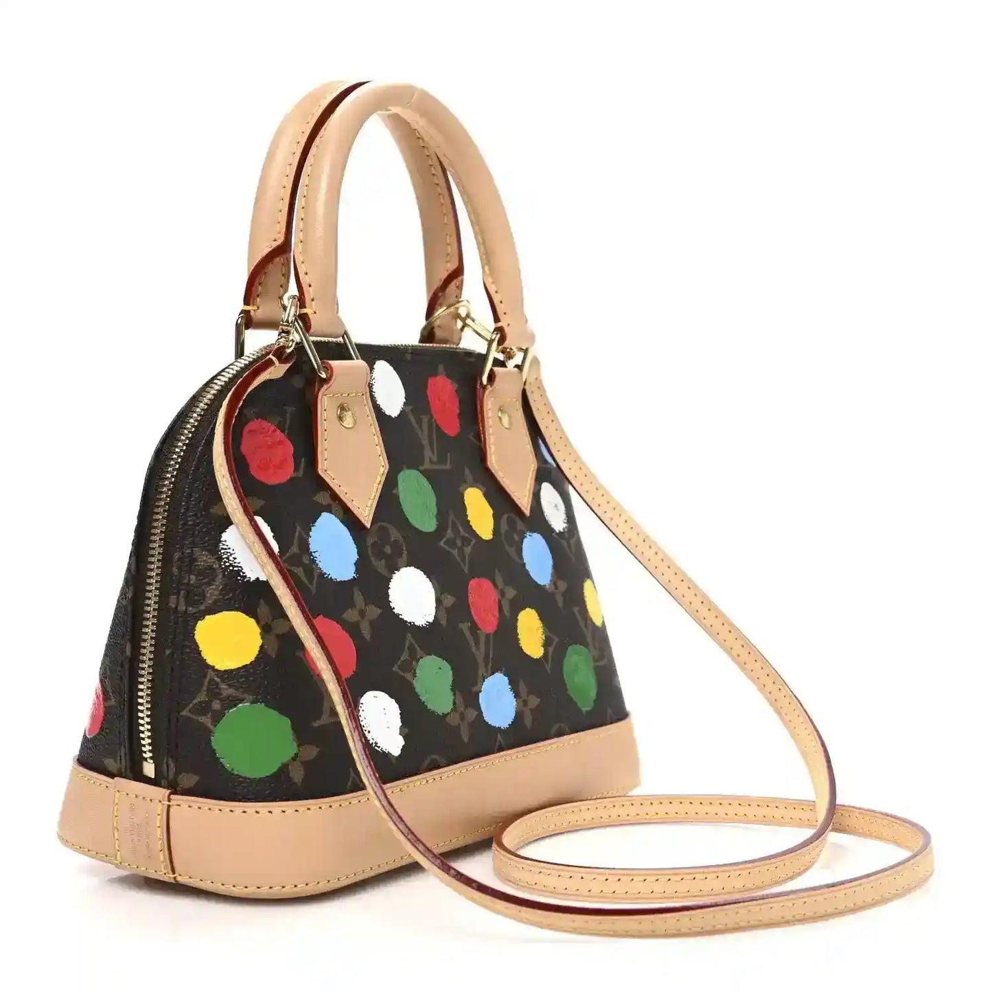 Small dot-print handbag with tan handles and crossbody strap, top zipper.