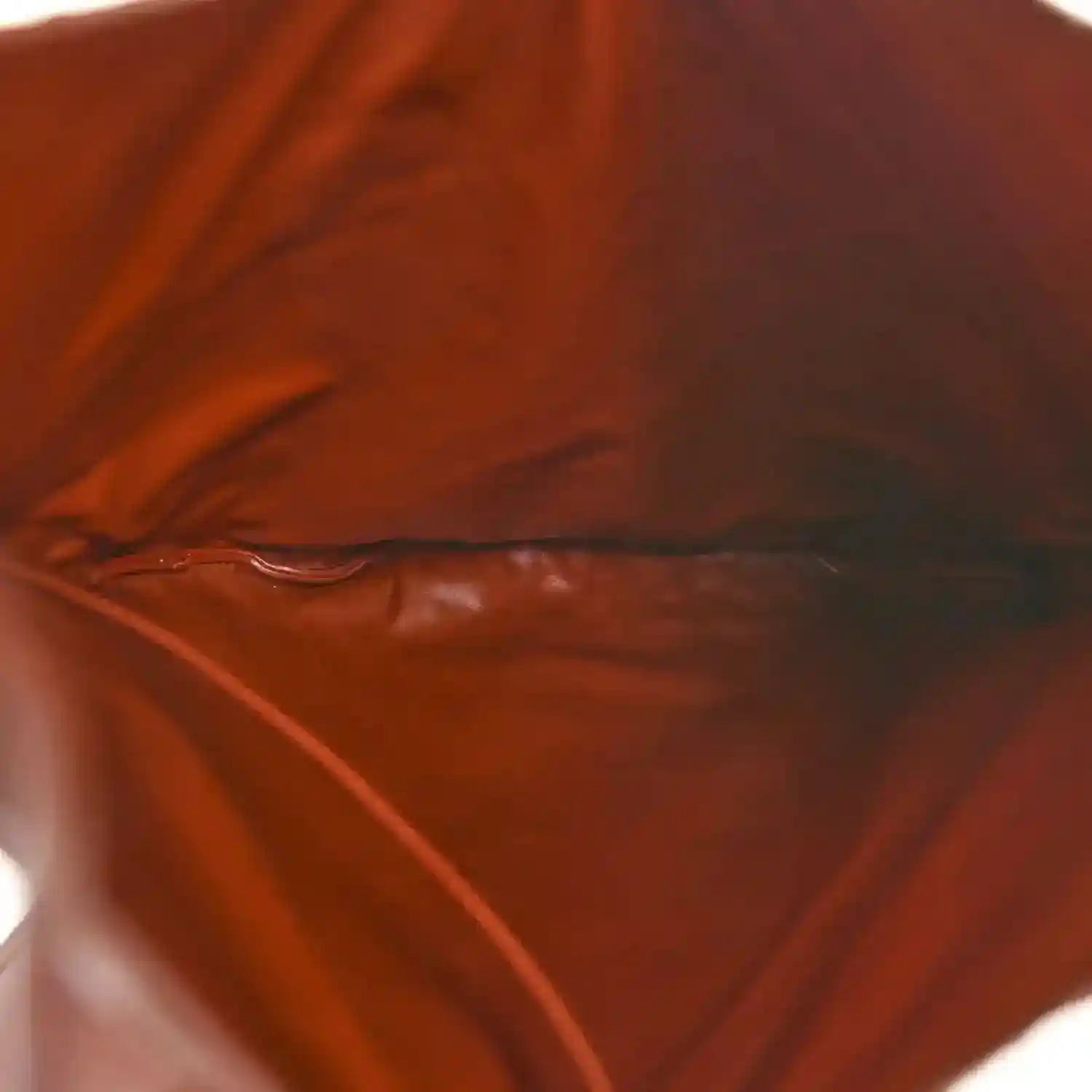 Brown leather interior with smooth lining and visible creases.