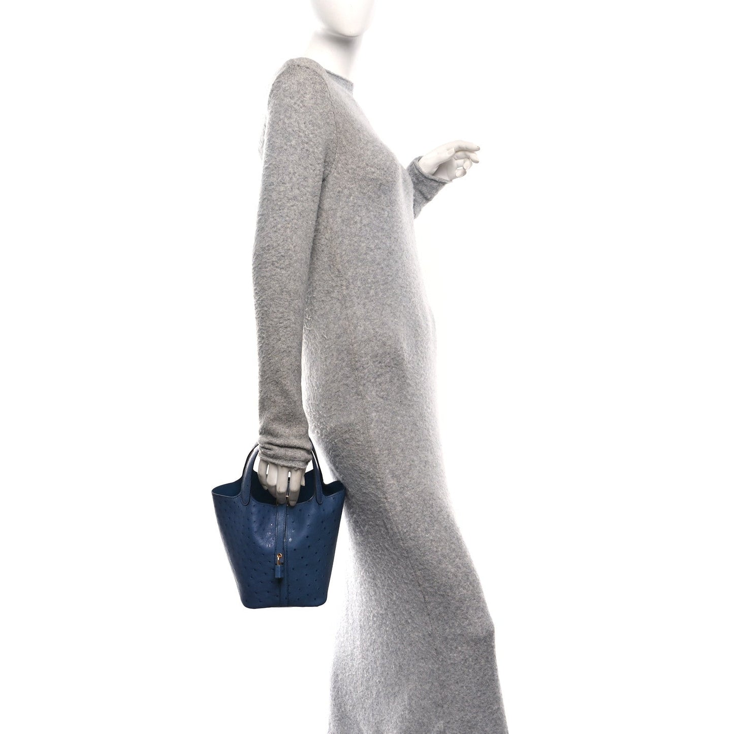 Blue ostrich leather bucket bag carried in hand with gold front clasp and top handles