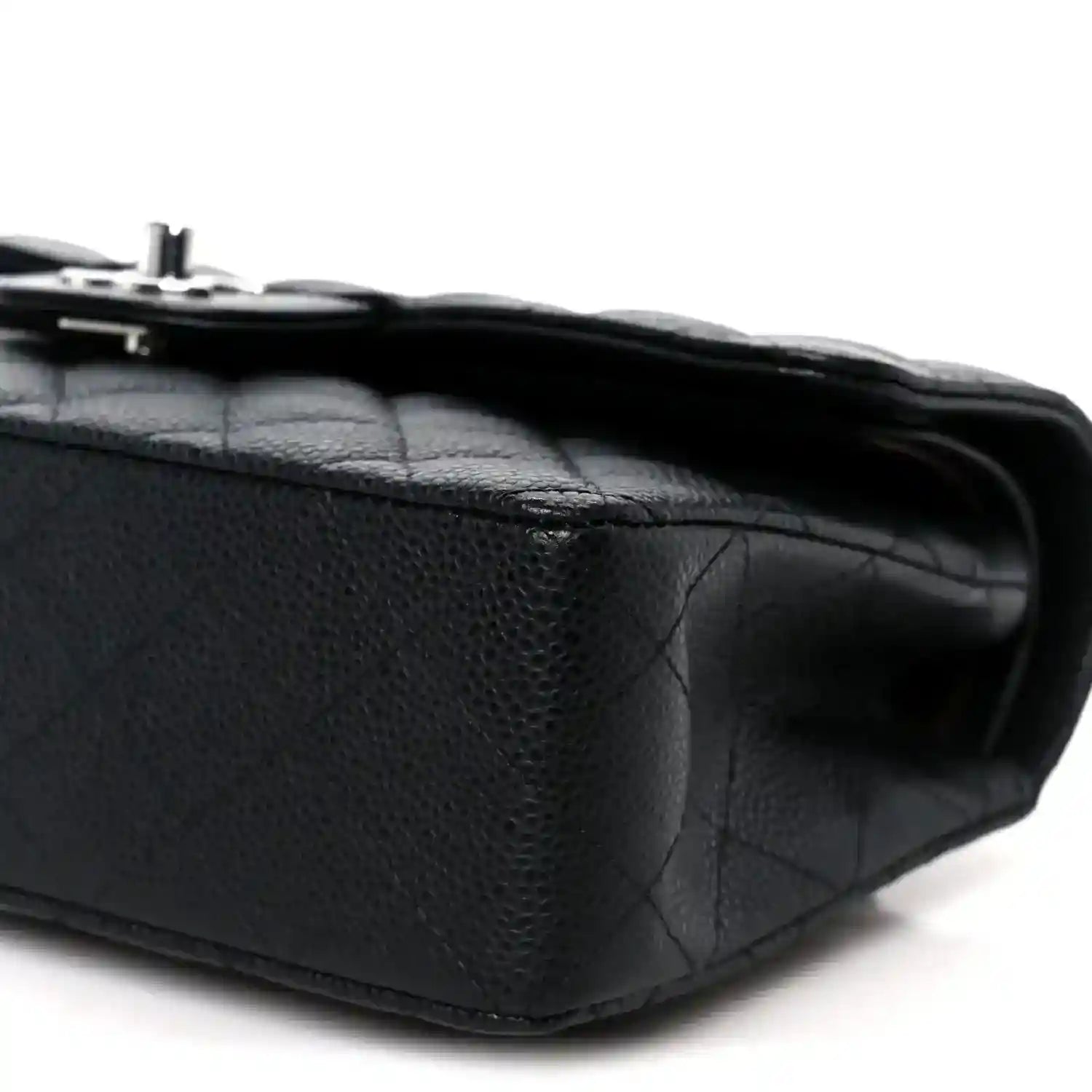 Black caviar-quilted leather flap bag corner detail with turn-lock hardware