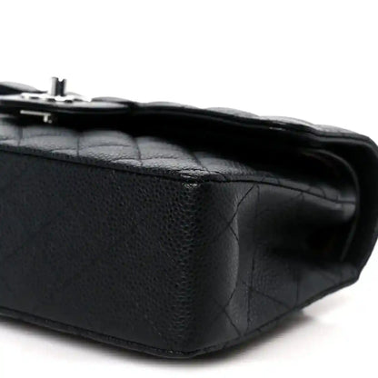 Black caviar-quilted leather flap bag corner detail with turn-lock hardware