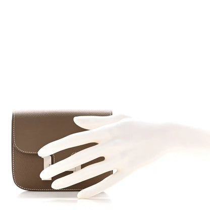 Taupe slim wallet with open front flap and H clasp, white contrast stitching
