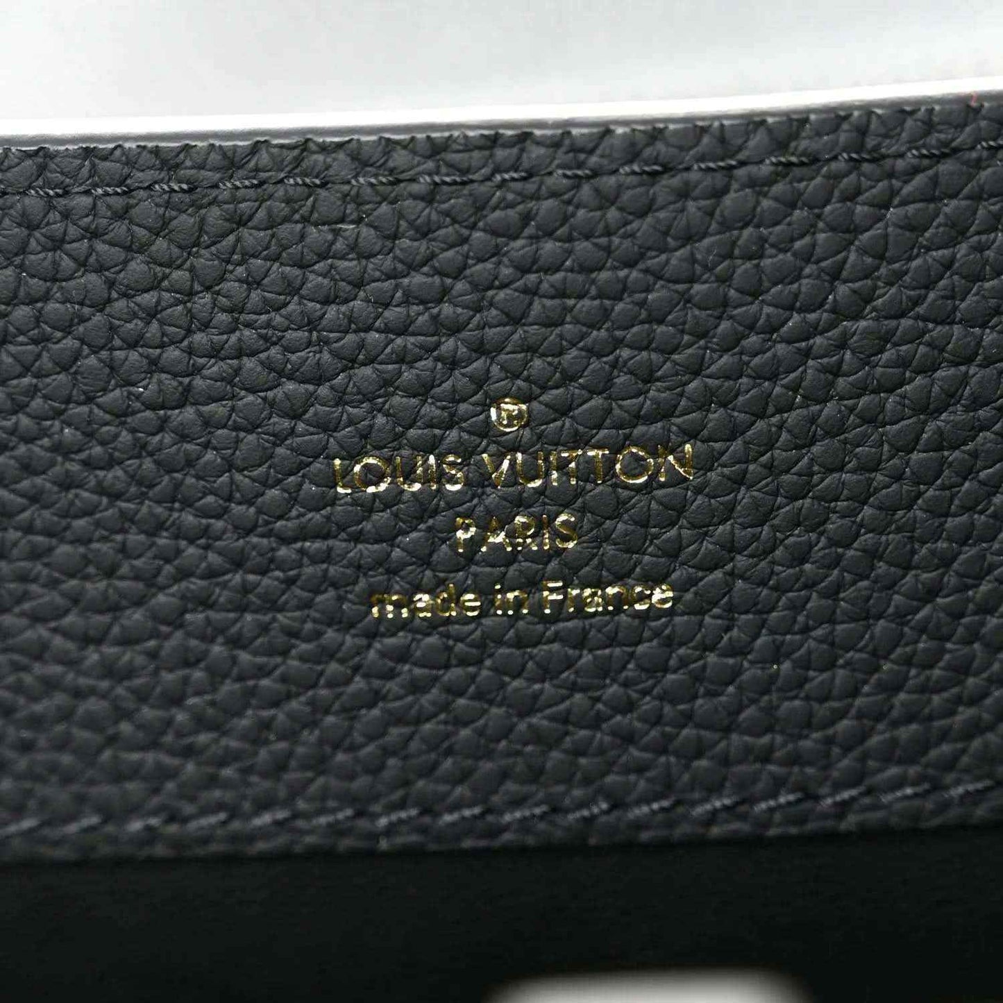 Matte black pebbled leather handbag with Louis Vuitton gold logo patch