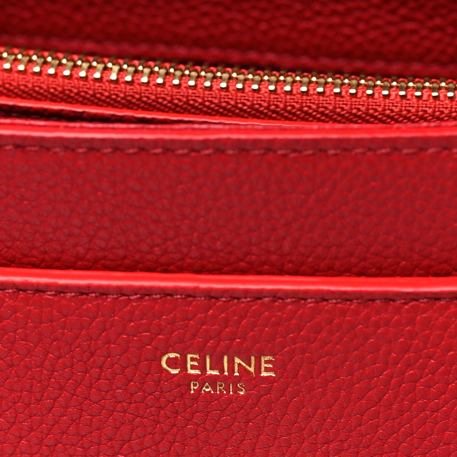 Celine red leather interior label with gold 'CELINE PARIS' embossing.