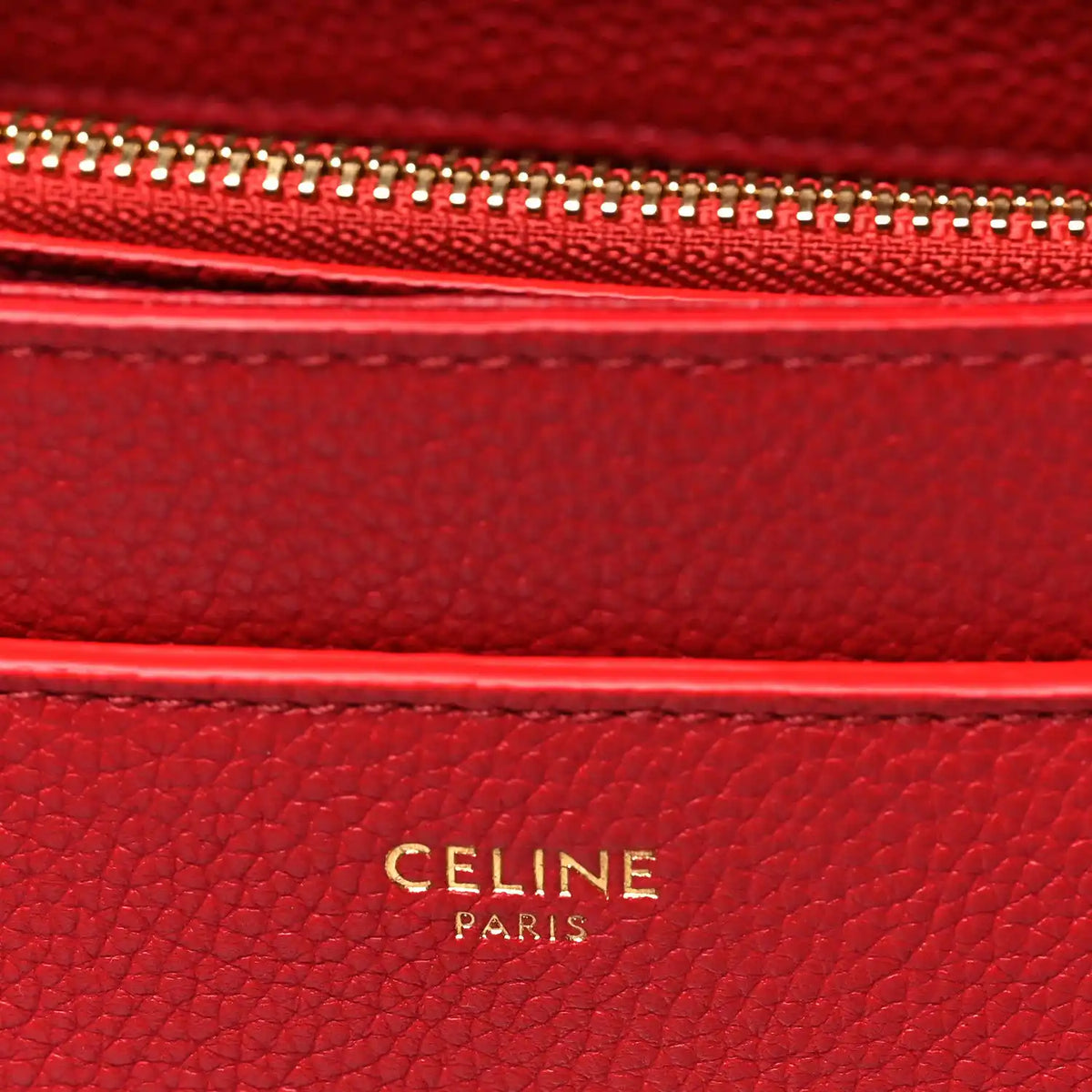 Celine red leather interior label with gold 'CELINE PARIS' embossing.