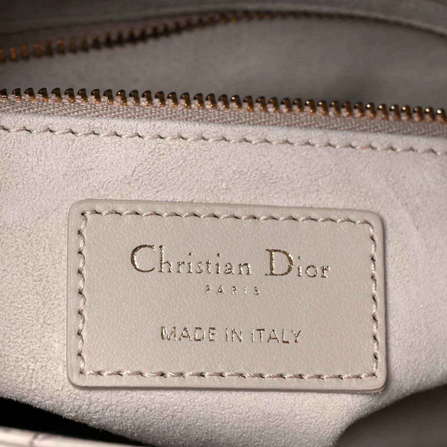 Handbag leather label reading Christian Dior and Made in Italy on beige lining
