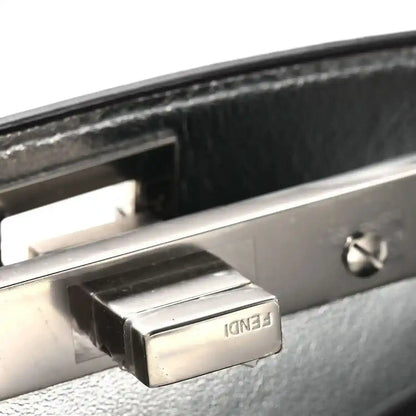 Silver-tone snap clasp on satchel frame with interior lining, close-up