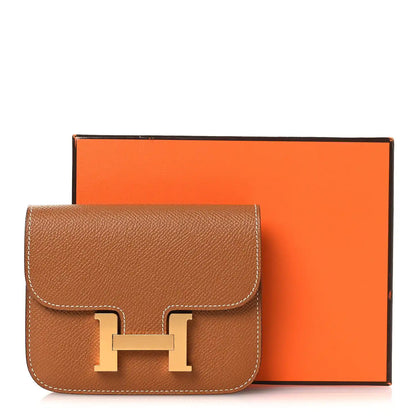 Constance slim wallet in textured tan leather with gold-tone H clasp and front flap