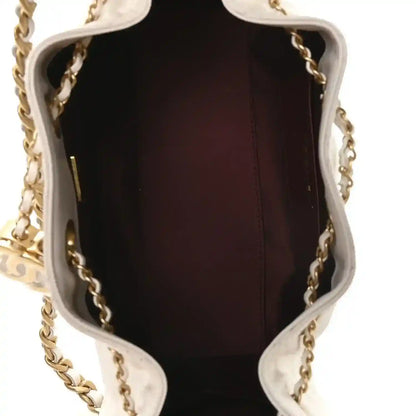 Open mini handbag interior with dark burgundy lining and gold chain hardware.