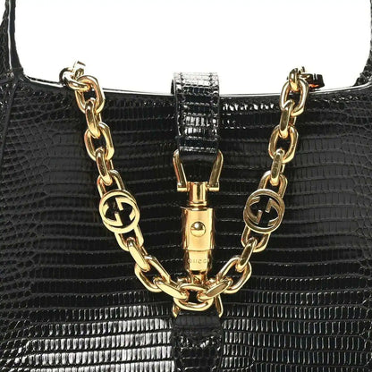 Black lizard mini Jackie handbag with gold-tone chain links and front clasp centerpiece.