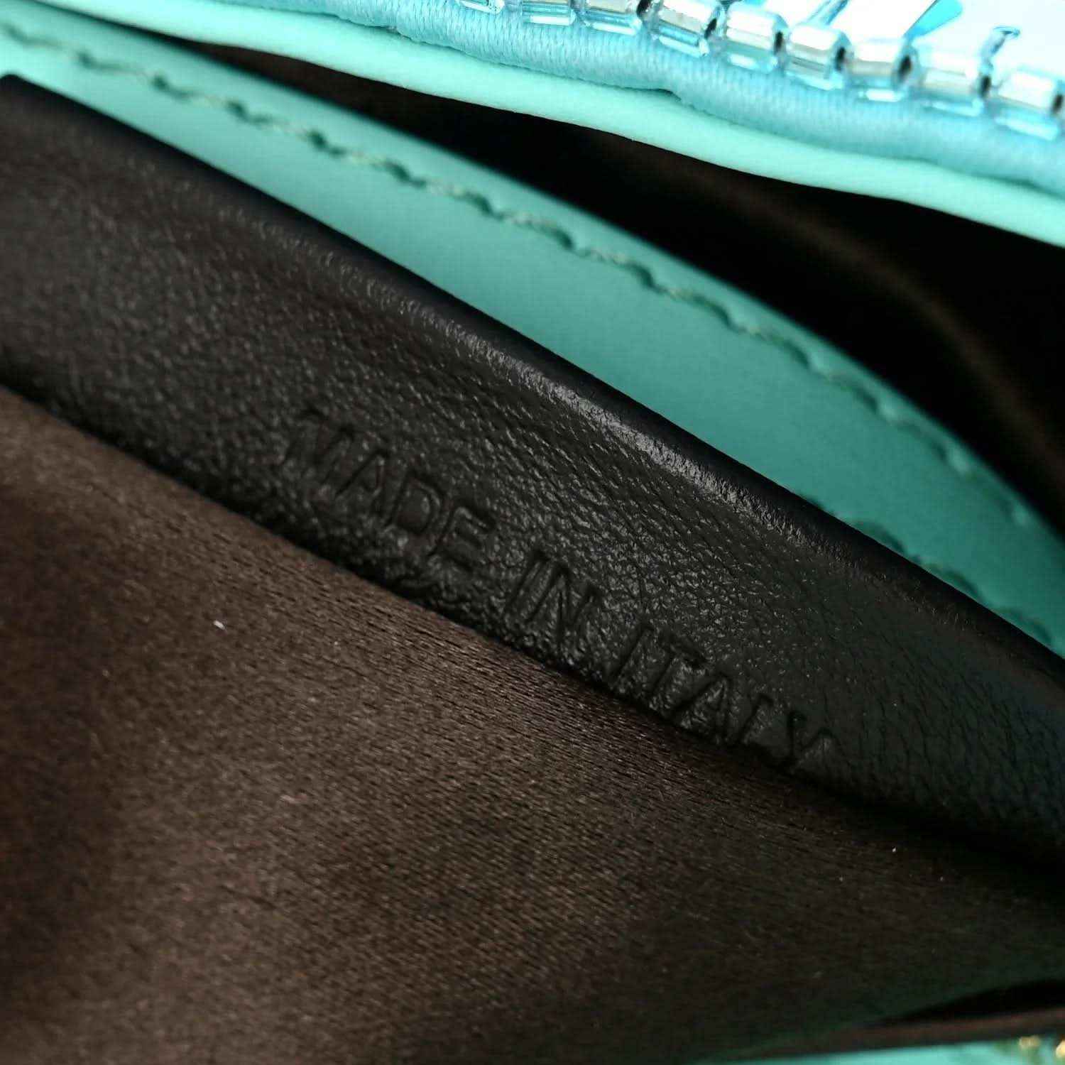 Turquoise leather interior trim with stitched edge inside the baguette bag