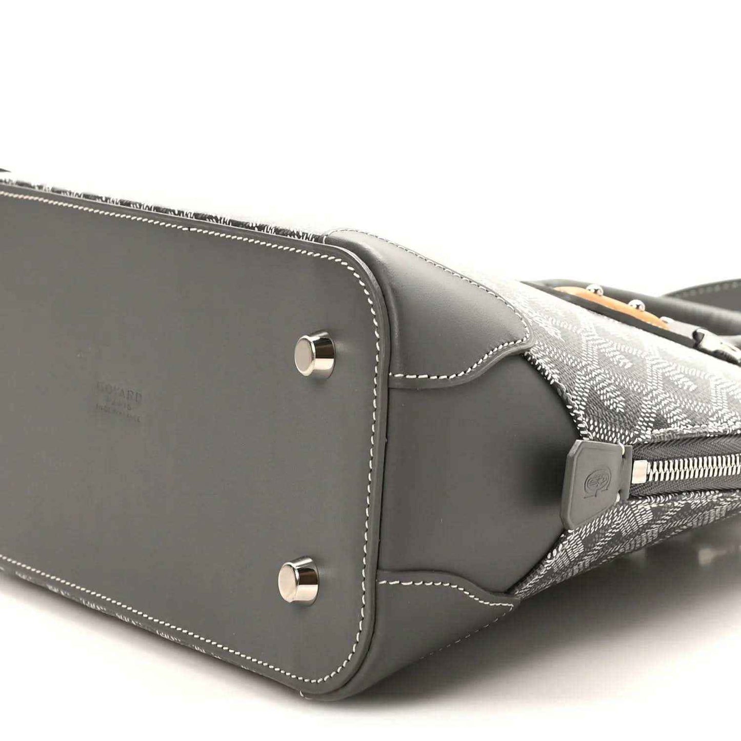 Grey handbag side panel with silver studs and contrast white stitching detail.